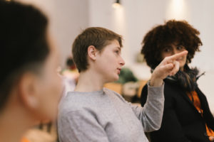 university students in the classroom discuss a project together at a presentation by the professor