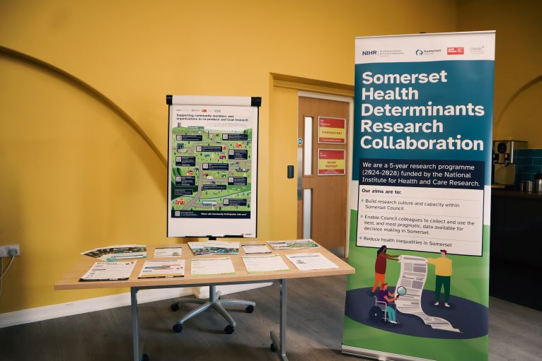 Somerset Health Determinants Research Collaboration exhibition stand with information resources and promotional materials.